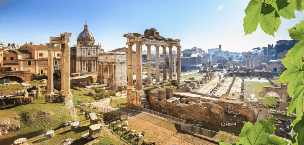 The sun-drenched ruins of the Roman Forum and ancient columns under a clear blue sky in Rome, Italy.