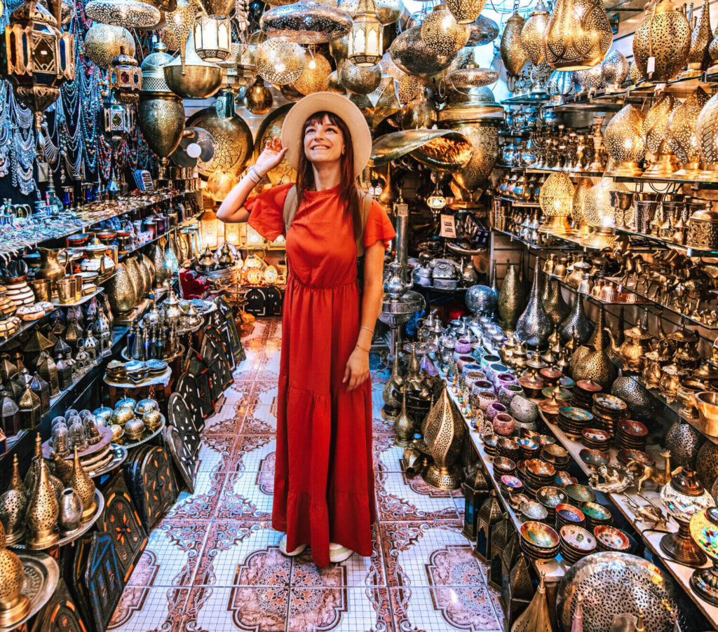 Young traveling woman visiting a copper souvenir handicraft shop in Marrakesh, Morocco