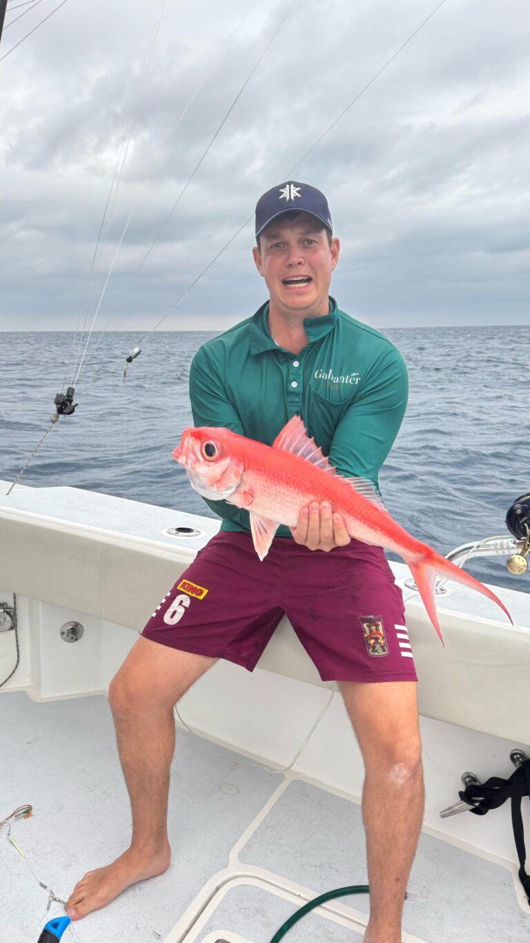 Liam holding a his freshly caught fish,.