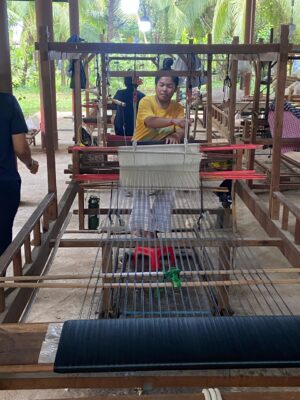 Woman using a machine to process silk
