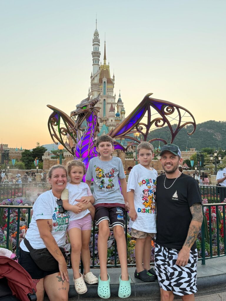 Brit's family in front of a dragon in Disneyland